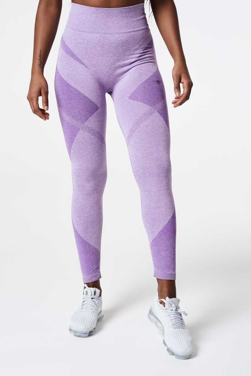 Close-up of a woman’s legs facing forward, wearing vibrant violet bold seamless performance leggings, highlighting comfort and flexibility.