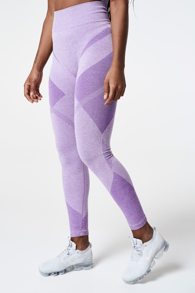 View of a Black woman’s legs walking, wearing Violet Bold Seamless Performance Leggings, showcasing the smooth fit and vibrant color of the leggings.