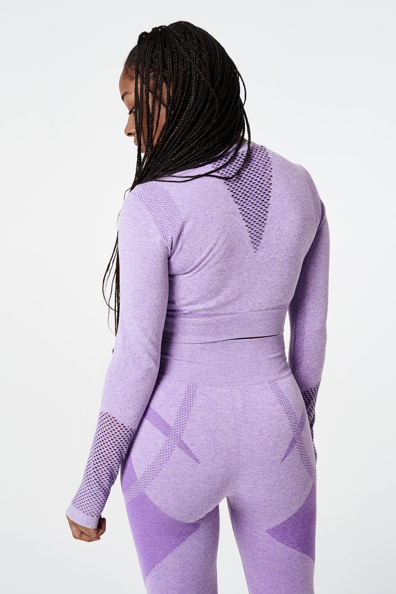 Close-up of the back of a Black woman wearing a violet pink bold seamless performance long-sleeve crop top with mesh details on the arms, paired with matching leggings, showcasing the stylish and athletic design.